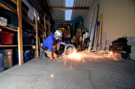 Electric wheel grinding on steel pipe in work space.の写真素材