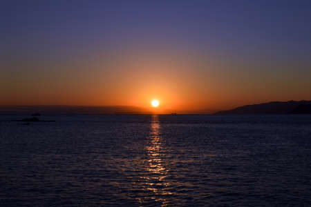 The winter sea and setting sunの写真素材