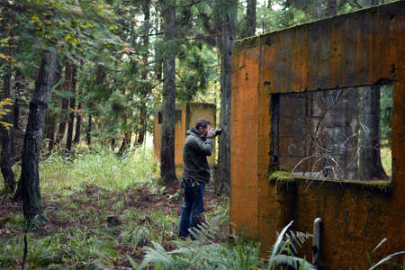 The man takes a photograph in the mountains of Kyoto, Japanの写真素材