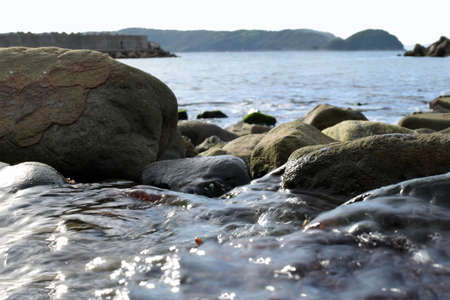 The sea which can be seen from the inside of a waterfallの写真素材