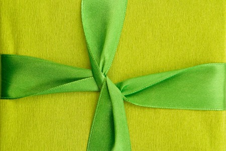 A green box tied with a green satin ribbon bow. A gift for Christmas, Birthday, Wedding, or Valentine's day. Isolated on white with clipping path.の写真素材
