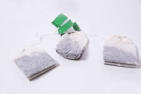 Tea bags are small little bags from a special filter paper in which tea is. They are used to the easy preparation by tea drinks, while one hangs them in hot water and allows to move some minutes. In addition most tea bags do not own a knotted string attacの写真素材