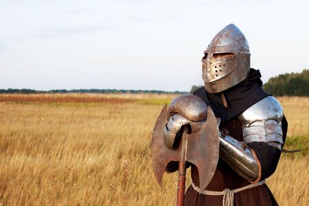 Medieval knight in the field with an axeの写真素材