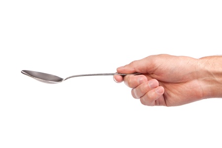 Hand is holding a spoon isolated on a white backgroundの写真素材