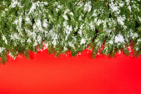 Christmas framework, postcard with snow isolated on red paper backgroundの写真素材