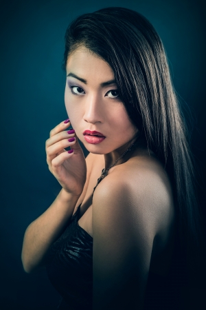 Beauty Portrait. Beautiful brunette Asian woman with long black hair. Shot in a studio on a black backgroundの写真素材