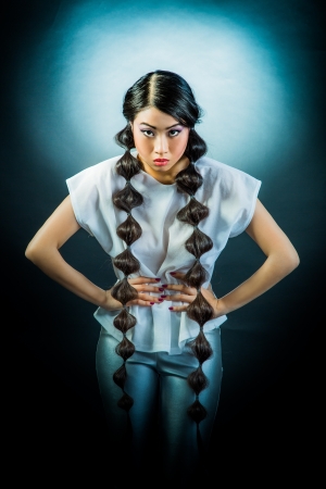 Beauty Portrait. Beautiful brunette Asian woman with long black hair. Shot in a studio on a black backgroundの写真素材