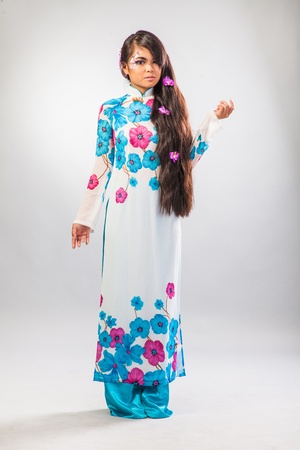 Beautiful asian woman wears a national dress isolated on a grey backroundの写真素材