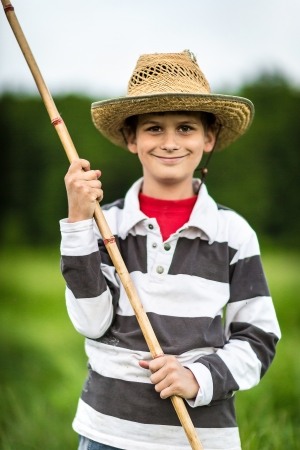 Photo of little kid pulling rod while fishing on weekendの写真素材