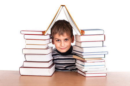 Schoolboy and a heap of books isolated on a white background