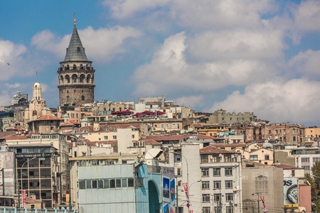 ISTANBUL - MAY 24, 2013: Tourist boat floats past the Galata tower at sunset on may 24, 2013 in Istanbul, Turkey. Golden Horn and the historic Galata area attracts tourists from all over the world.のeditorial素材