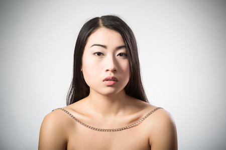 Beauty Portrait. Beautiful brunette Asian woman with long black hair. Shot in a studio on a white backgroundの写真素材