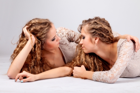 Two beautiful girls twins, isolated on the grey backgroundの写真素材