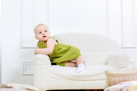 little kid sit on a sofa and playの写真素材