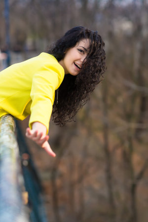 A beautiful girl in a park on a background of green nature