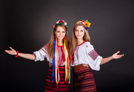 Young women in ukrainian clothes, with garland  on black backgroundの写真素材