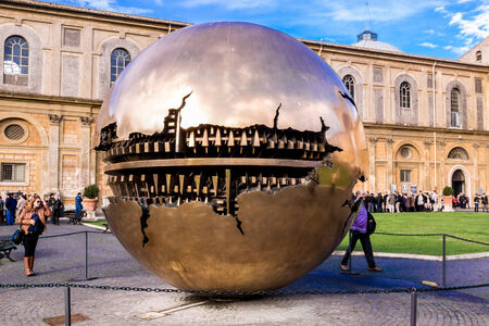 VATICAN - OCTOBER14: People around Sphere within sphere in Courtyard of the Pinecone at Vatican Museums at October 14, 2011. Sphere was created in 1990 by Italian sculptor Arnoldo Pomodoro.のeditorial素材