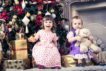 Christmas. Two Cheerful little baby girl with christmas presentの写真素材