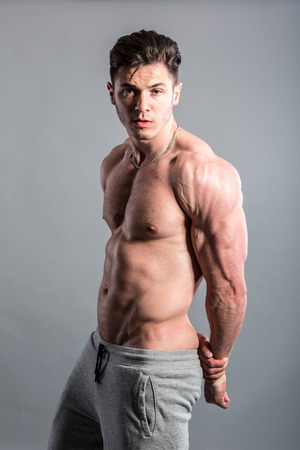 Handsome muscular man posing against a dark backgroundの写真素材