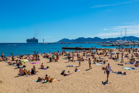 CANNES, FRANCE - JUNE 23, 2016: People on popular beach in Cannes in a beautiful summer day, France on June 23, 2016