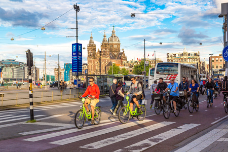 AMSTERDAM, THE NETHERLANDS - JUNE 16, 2016: People riding bicycles in historical part of Amsterdam in a beautiful summer day, The Netherlands on June 16, 2016のeditorial素材