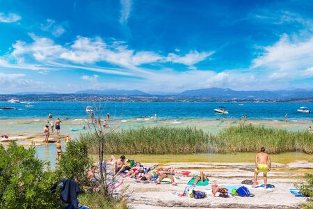 SIRMIONE, ITALY - JUNE 16, 2016: Garda lake, Public beach in Sirmione in a beautiful summer day, Italy on June 16, 2016のeditorial素材