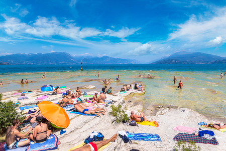 SIRMIONE, ITALY - JUNE 16, 2016: Garda lake, Public beach in Sirmione in a beautiful summer day, Italy on June 16, 2016のeditorial素材