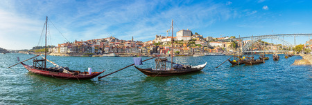 Traditional boats with wine barrels and Douro River in Porto in a beautiful summer day, Portugalの写真素材