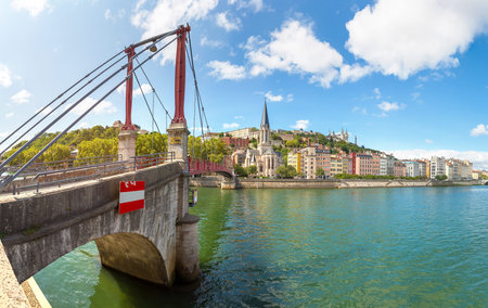 Pedestrian Saint Georges footbridge and the Saint Georges church in Lyon, France in a beautiful...