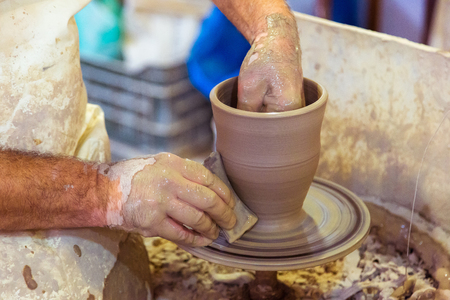 Hands of an old potter creating a jarの写真素材