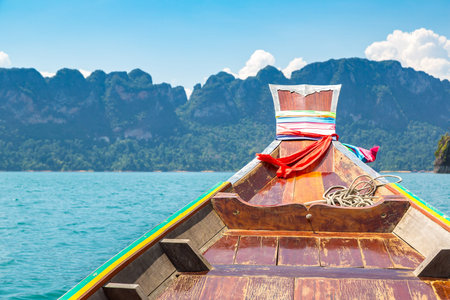 Wooden thai traditional long tail boat on Cheow Lan lake, Ratchaprapha Dam, Khao Sok National Park...
