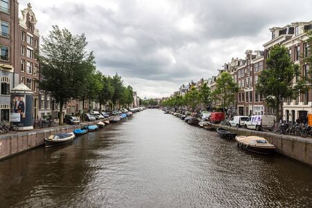 AMSTERDAM, THE NETHERLANDS - JUNE 16, 2016: Canal in Amsterdam in a beautiful summer day. Amsterdam is the capital and the most populous city of the Netherlands on June 16, 2016のeditorial素材