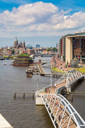 AMSTERDAM, THE NETHERLANDS - JUNE 16, 2016: Canal and St. Nicolas Church in Amsterdam in a beautiful summer day, The Netherlandsのeditorial素材