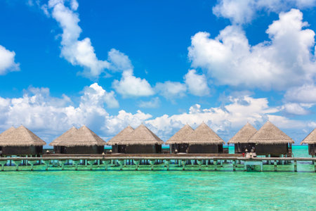 MALDIVES - JUNE 24, 2018: Water Villas (Bungalows) and wooden bridge at Tropical beach in the...