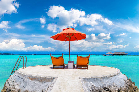 MALDIVES - JUNE 24, 2018: Wooden sunbed and umbrella on tropical beach in the Maldives at summer dayのeditorial素材