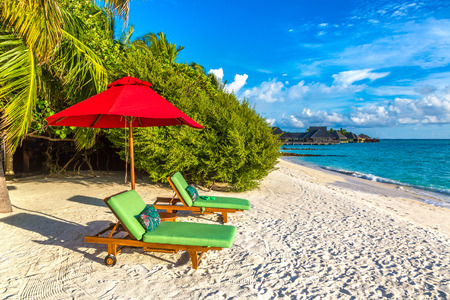 MALDIVES - JUNE 24, 2018: Wooden sunbed and umbrella on tropical beach in the Maldives at summer dayのeditorial素材
