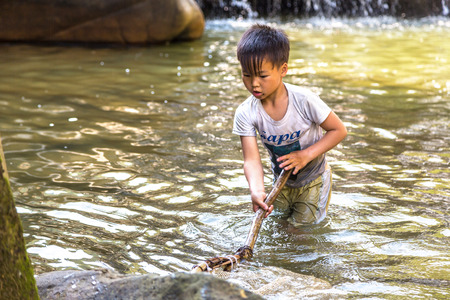 SAPA, VIETNAM - JUNE 19, 2018: Boy fishing at the river in Sapa, Lao Cai, Vietnam in a summer dayのeditorial素材