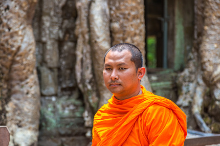 SIEM REAP, CAMBODIA - JUNE 11, 2018: Buddhist monk at Ta Prohm temple ruins is Khmer ancient temple in complex Angkor Wat in Siem Reap, Cambodiaのeditorial素材