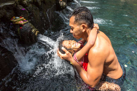 BALI, INDONESIA - FEBRUARY 28, 2020: Balinese people pray in pool holy water in Pura Tirta Empul Temple on Bali, Indonesiaのeditorial素材