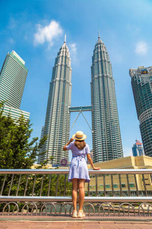 KUALA LUMPUR, MALAYSIA - FEBRUARY 25, 2020: Woman traveler at  Petronas Tower in a sunny day in Kuala Lumpur, Malaysiaのeditorial素材