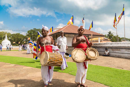 ANURADHAPURA, SRI LANKA - FEBRUARY 12, 2020: Musicians and drummers near Big white Ruwanwelisaya stupa in Anuradhapura Archaeological Museum in Sri Lankaのeditorial素材