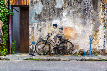 PENANG, MALAYSIA - FEBRUARY 22, 2020: Famous Mural graffiti of "little children on a bicycle" by Lithuanian artist Ernest Zacharevic in Georgetown, Penang, Malaysiaのeditorial素材