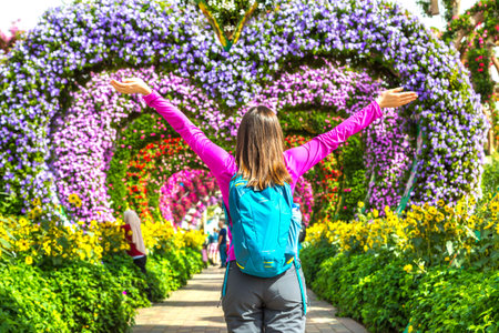 DUBAI, UNITED ARAB EMIRATES - JANUARY 31, 2020: Tourist woman and colorful heart shaped flowers alley in Dubai miracle garden in a sunny day , United Arab Emiratesのeditorial素材