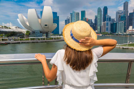 SINGAPORE, SINGAPORE - FEBRUARY 26, 2020:  Woman traveler looking at ArtScience Museum in a sunny day in Singaporeのeditorial素材