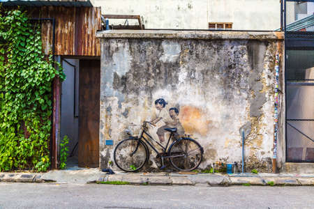 PENANG, MALAYSIA - FEBRUARY 22, 2020: Famous Mural graffiti of "little children on a bicycle" by Lithuanian artist Ernest Zacharevic in Georgetown, Penang, Malaysiaのeditorial素材