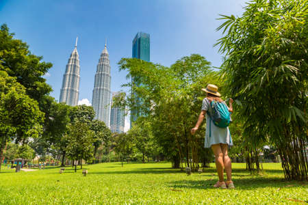 KUALA LUMPUR, MALAYSIA - FEBRUARY 25, 2020: Woman traveler at  Petronas Tower in a sunny day in Kuala Lumpur, Malaysiaのeditorial素材