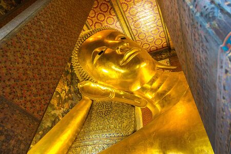 Giant Reclining Buddha inside Wat Pho Temple in Bangkok in a summer dayの写真素材