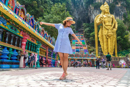 KUALA LUMPUR, MALAYSIA - FEBRUARY 25, 2020: Woman traveler at  Batu cave, hinduism temple in a sunny day in Kuala Lumpur, Malaysiaのeditorial素材
