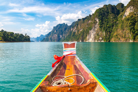 Wooden thai traditional long tail boat on Cheow Lan lake, Ratchaprapha Dam, Khao Sok National Park...