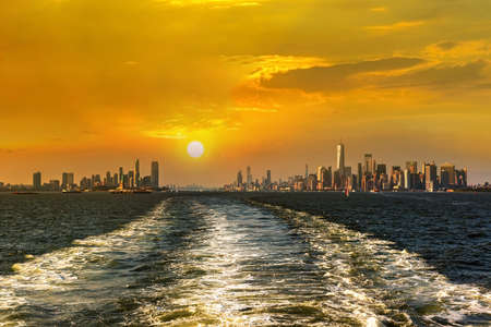 Cruise wash foam in Hudson river and Panoramic view of Statue of Liberty and Manhattan and Jersey city  in New York City, NY, USAの写真素材